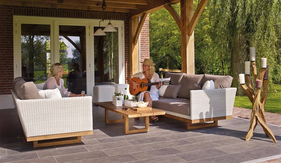 Covered patio seating with glass doors opening from the house behind it.