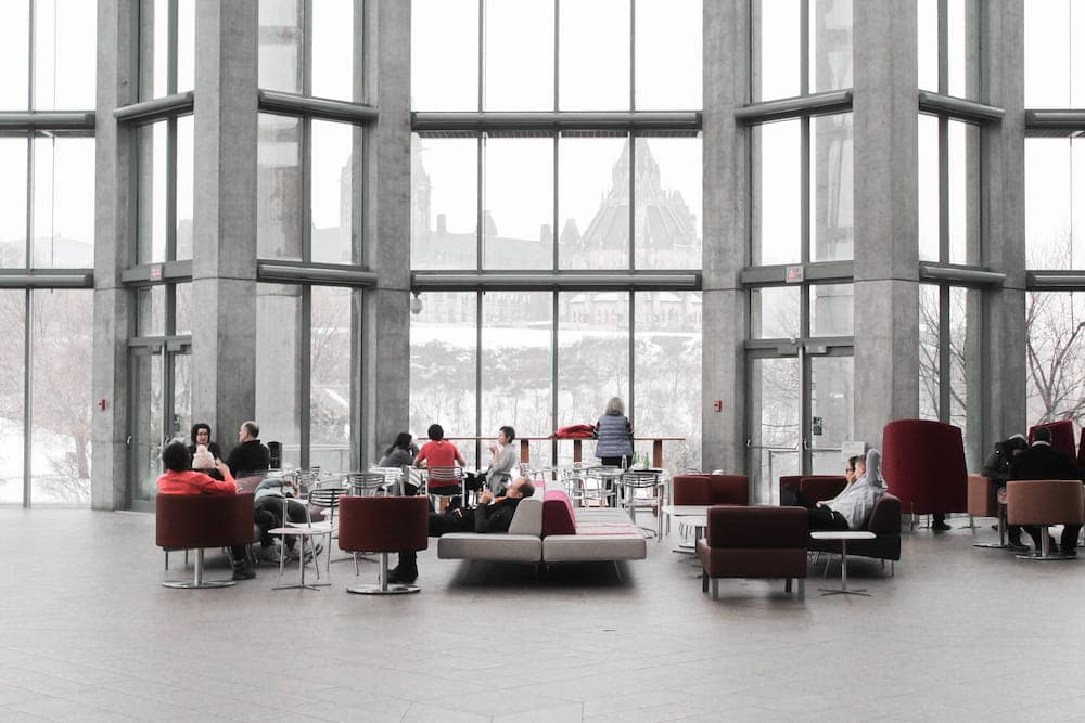 people sitting on couches and glass window framed wall