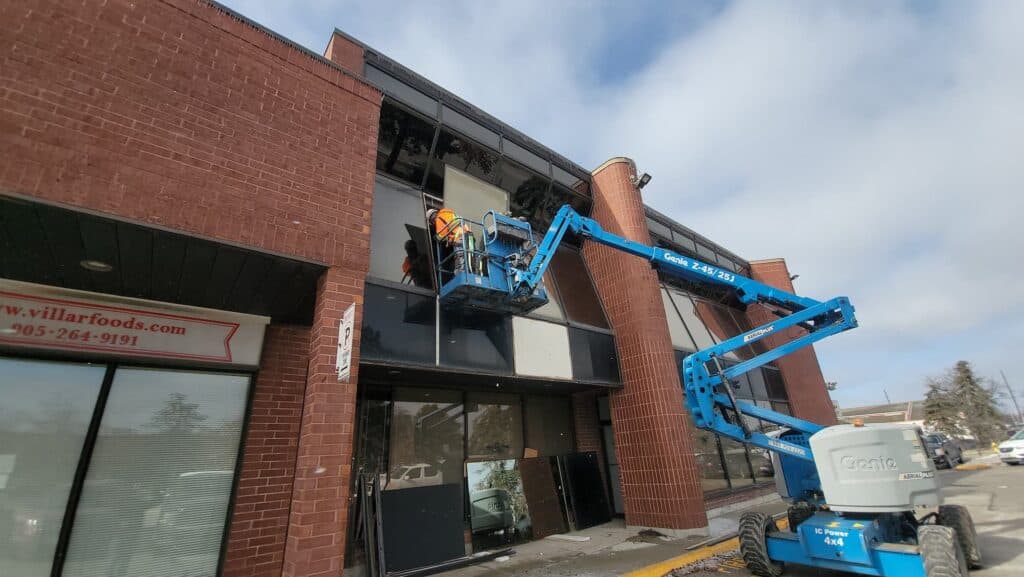 Lift working on the upper windows of a brick commercial building