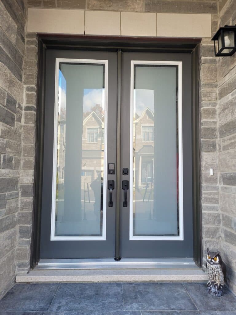 Dark double front doors with frosted glass panels in a stone entry.