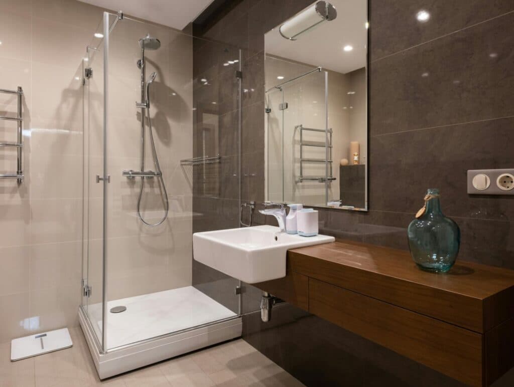 Bathroom with a frameless glass shower beside a wall-mounted sink.