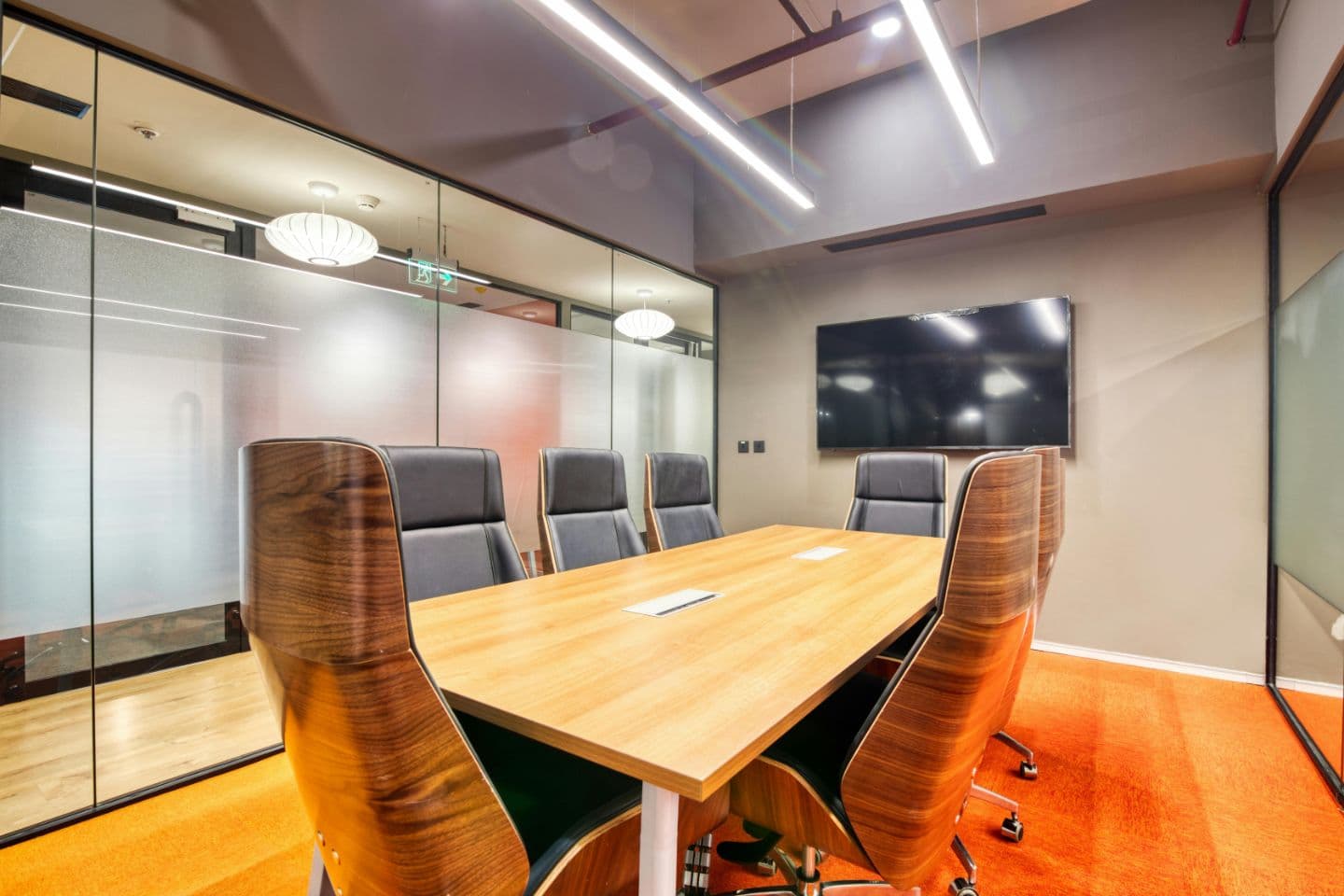 Conference room with a wood table and frosted glass walls.