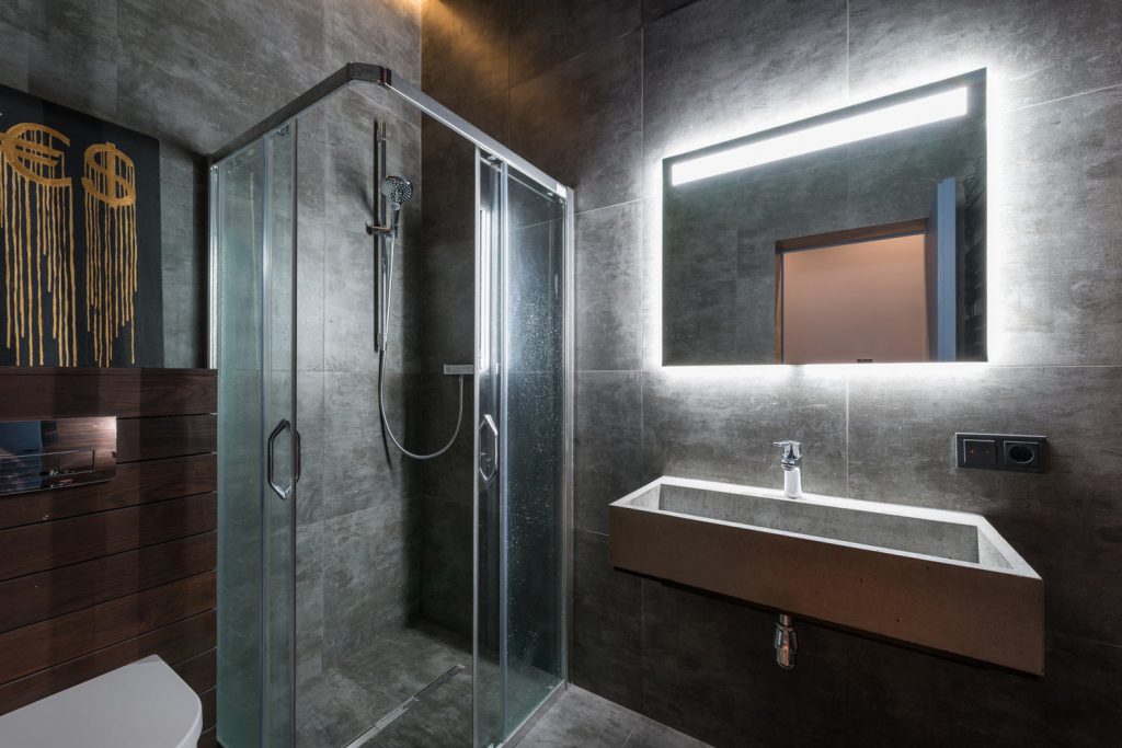 bathroom shower unit with glass door and floating vanity
